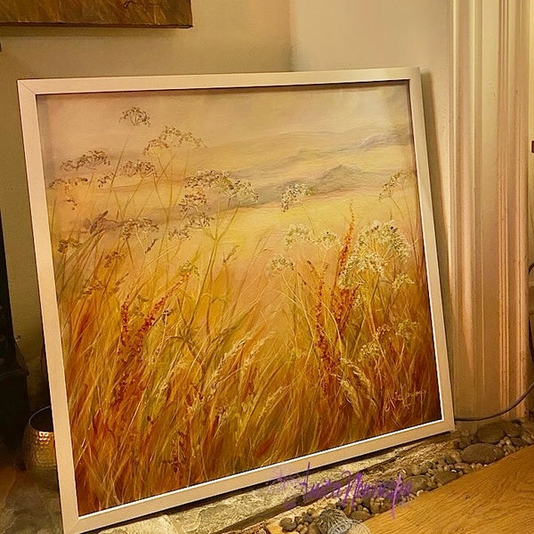 original meadow painting at golden hour by anita nowinska art soft warm tones of peach auburn amber and blue