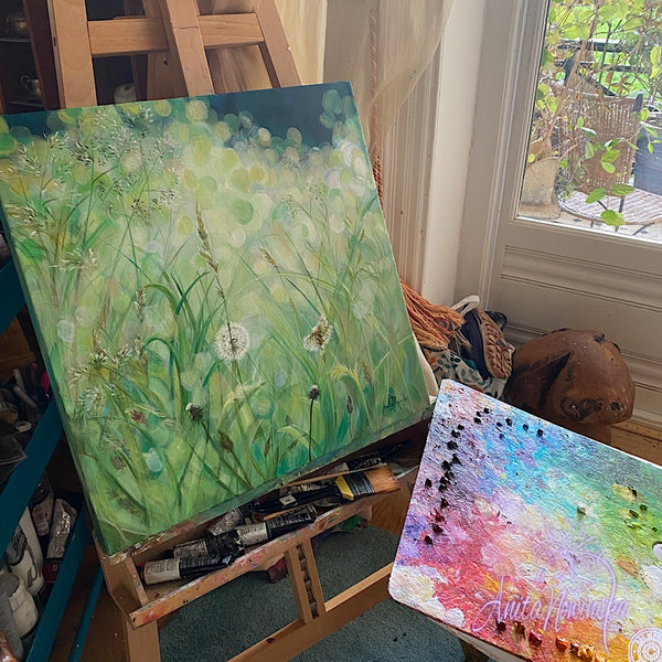calming small acrylic on canvas painting of green grass meadow in sunlight with dandelion seed heads by Anita Nowinska