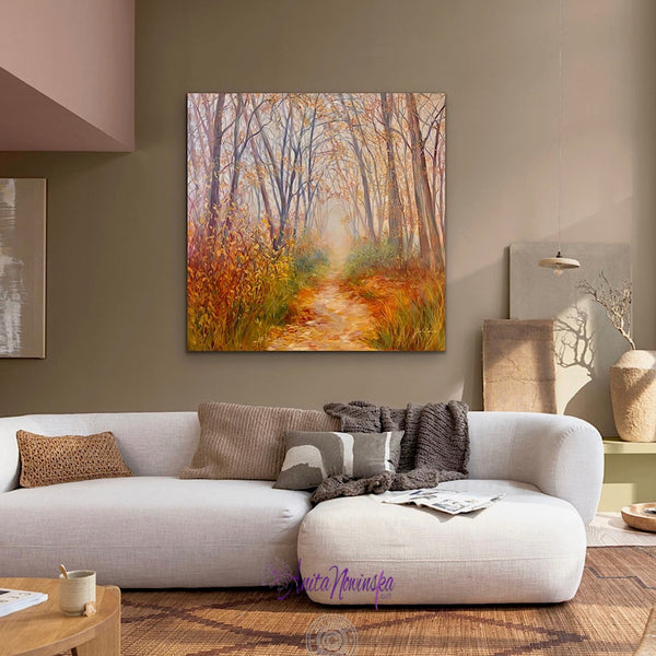 room with white sofa & mushroom beige walls with big canvas painting of a misty autumn woodland with a path by anita nowinska