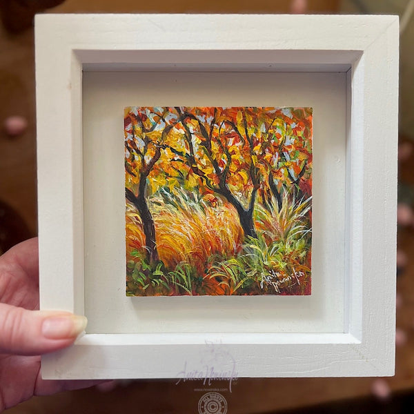 miniature oil painting in white frame of autumn trees surrounded by golden grasses and sunlight by anita nowinska