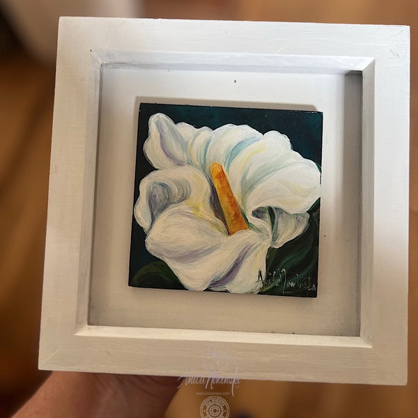 Framed painting of a white peace lily flower with a dark background