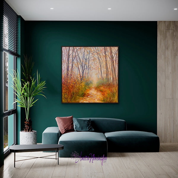 big painting of autumn trees with a path going towards light by anita nowinska in a room with teal and dark green