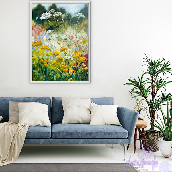 wild flower garden painting by anita nowinska in room with white walls & blue sofa. Yellow, gold, green colours